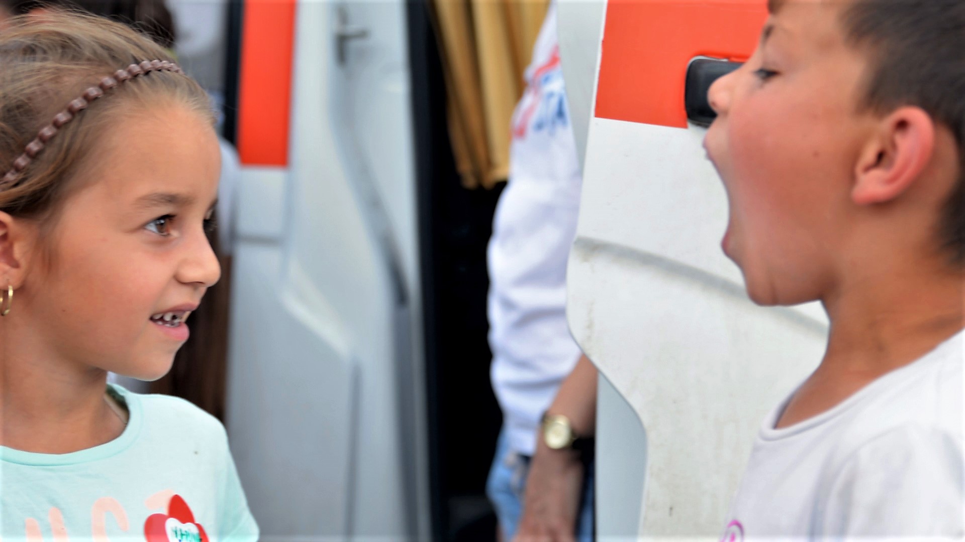 Doi copii din Viscri își arată unul altuia dinții după vizita în cabinetul mobil al "Zânei Merciluță"